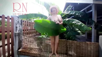 Rural striptease. Country girl dancing in the yard of her house Rustic striptease with banana leaf