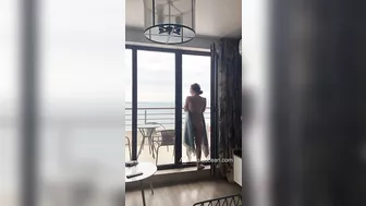 Sexy slender girl flashes her natural bare breasts on her balcony.