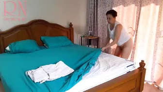 Nudist housekeeper Regina Noir makes the bedding in the bedroom. Naked maid. Naked housewife. c1