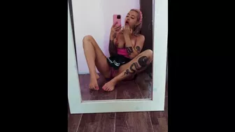 A busty beauty sits in front of a mirror and caresses her excited pussy.