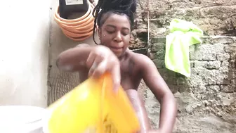 Black woman from Bahia bathing in a bucket in the backyard.