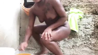 Black woman from Bahia bathing in a bucket in the backyard.