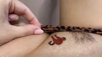 Tattoo master in leopard panty doing temporary tattoo