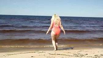 Juicy MILF in a pink swimsuit, on the beach