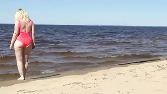 Juicy MILF in a pink swimsuit, on the beach